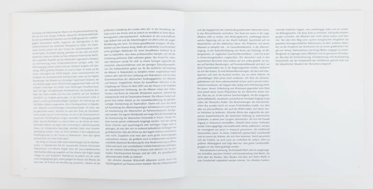 Open book lying flat on a white surface, two pages filled with dense German text.