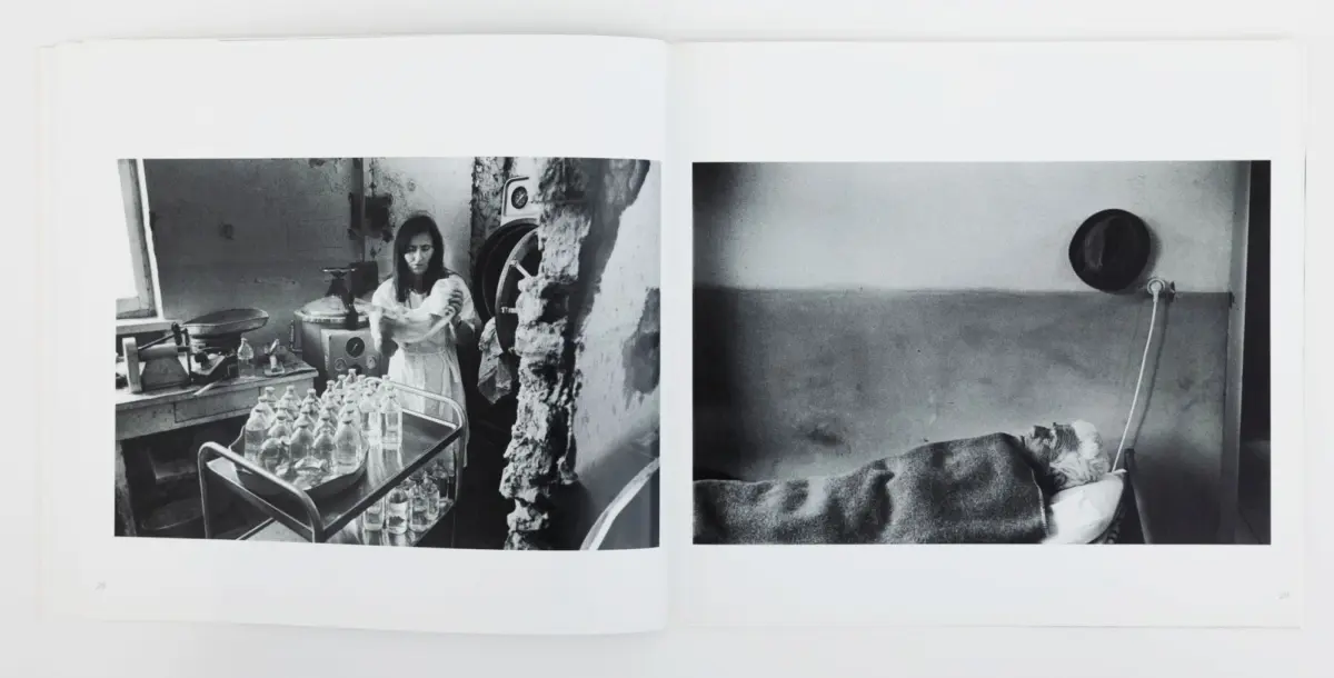 Open book shows two black-and-white photos: left, a woman adjusts clothing in a ruined room with water bottles; right, a patient in a hospital bed.