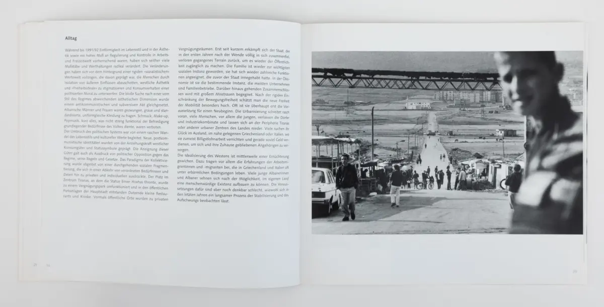 Open book spread; right page shows a black-and-white harbor construction scene with a long crane, pedestrians, and cars.