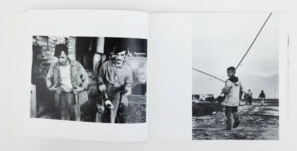 Two-page spread of black-and-white photos: left, two men in work clothes by a stone wall; right, boy with a fishing rod on a beach.