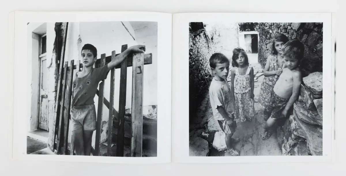 Two black-and-white photos: left, a boy leans on a wooden fence near a white building; right, four children in a rocky alley, one shirtless boy.