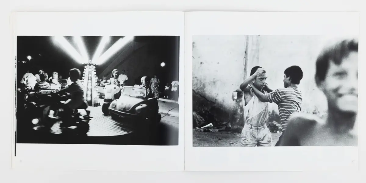Two-page spread: left—bumper cars at a carnival with bright lights; right—two boys in an alley, one adjusts the other's shirt.