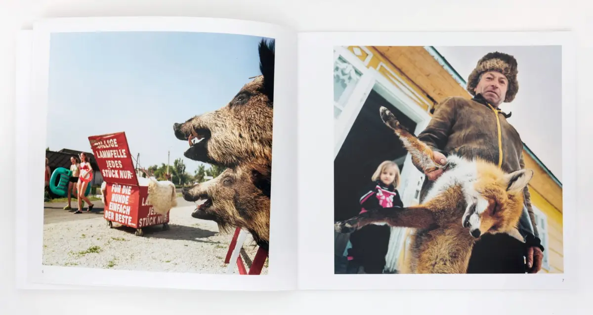 Two-page spread: left a large snarling dog near a red sign; right a man in a fur hat with a donkey in the foreground outdoors