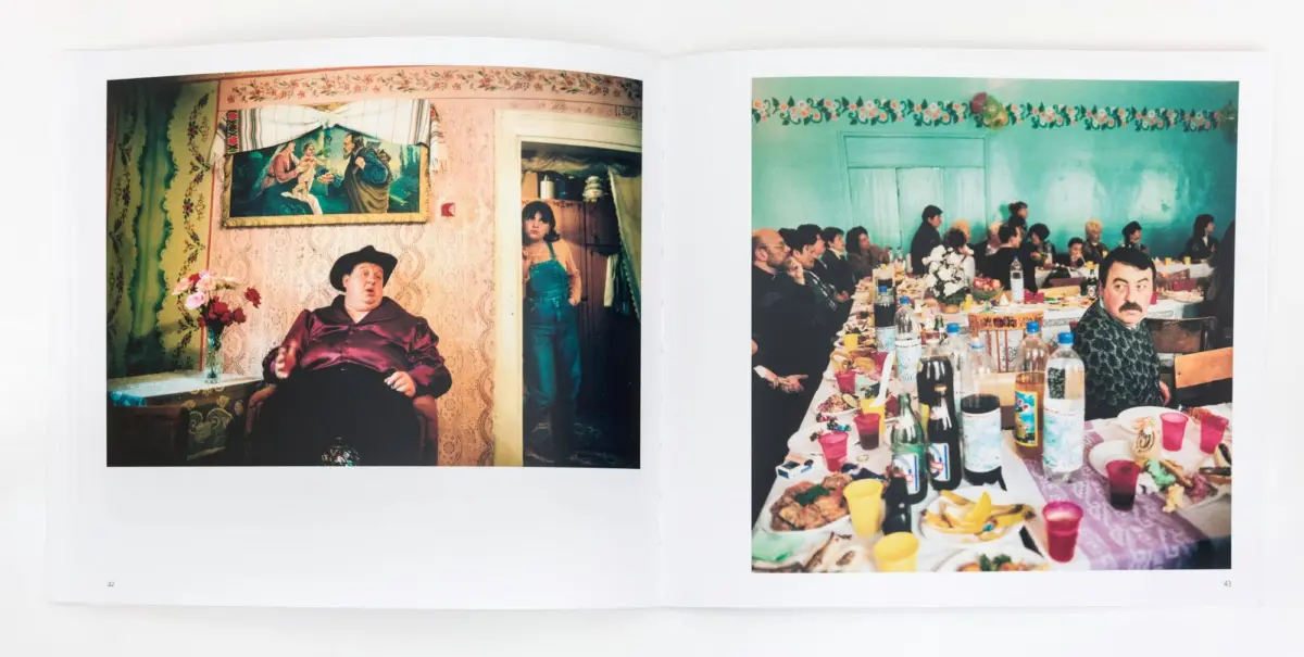 Left: heavyset man in maroon satin shirt and black hat seated in floral wallpaper room; girl in denim at doorway. Right: banquet with guests at long table; mustached man in foreground.