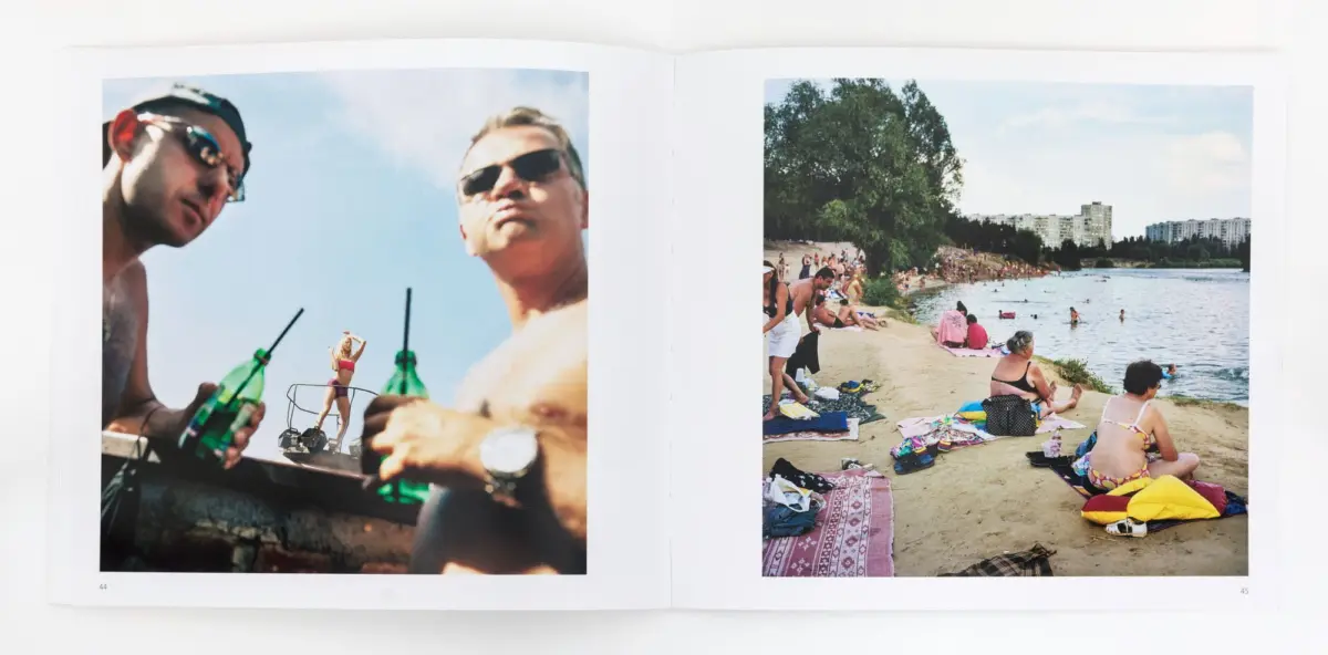 Two-page spread: left two men on a boat posing with green bottles; right crowded lakeside beach with sunbathers, swimmers, trees, distant apartments.