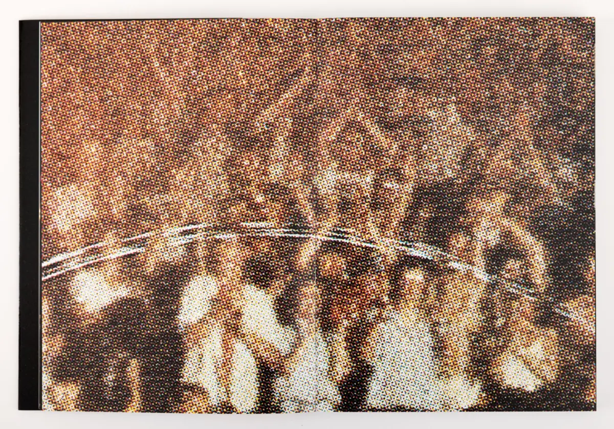 Crowd at a concert with raised hands, shown as a halftone photograph.