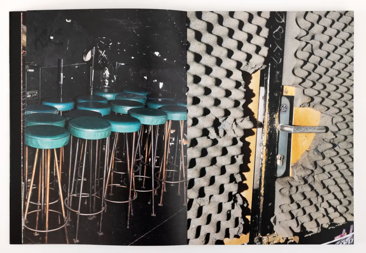 Recording studio scene with teal bar stools and microphone stands against a dark wall, and gray egg-crate acoustic foam on adjacent walls.
