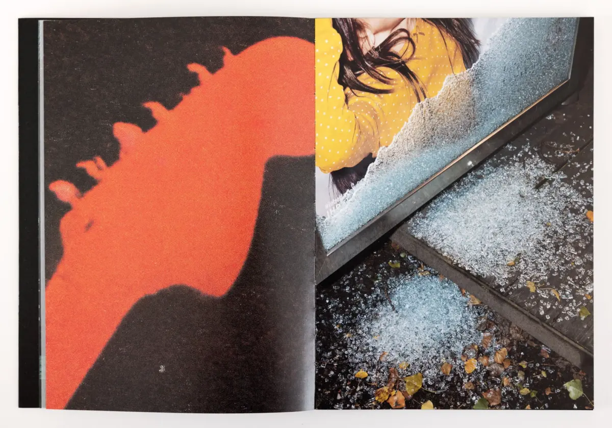 Open magazine spread: left page orange and black abstract pattern; right page shows a person in a yellow polka-dot sweater leaning on frosted panel.