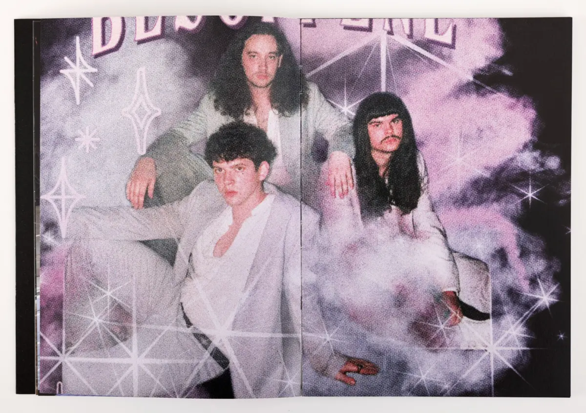 Four people in white outfits pose together against a purple, smoky backdrop with star shapes; magazine spread photo.