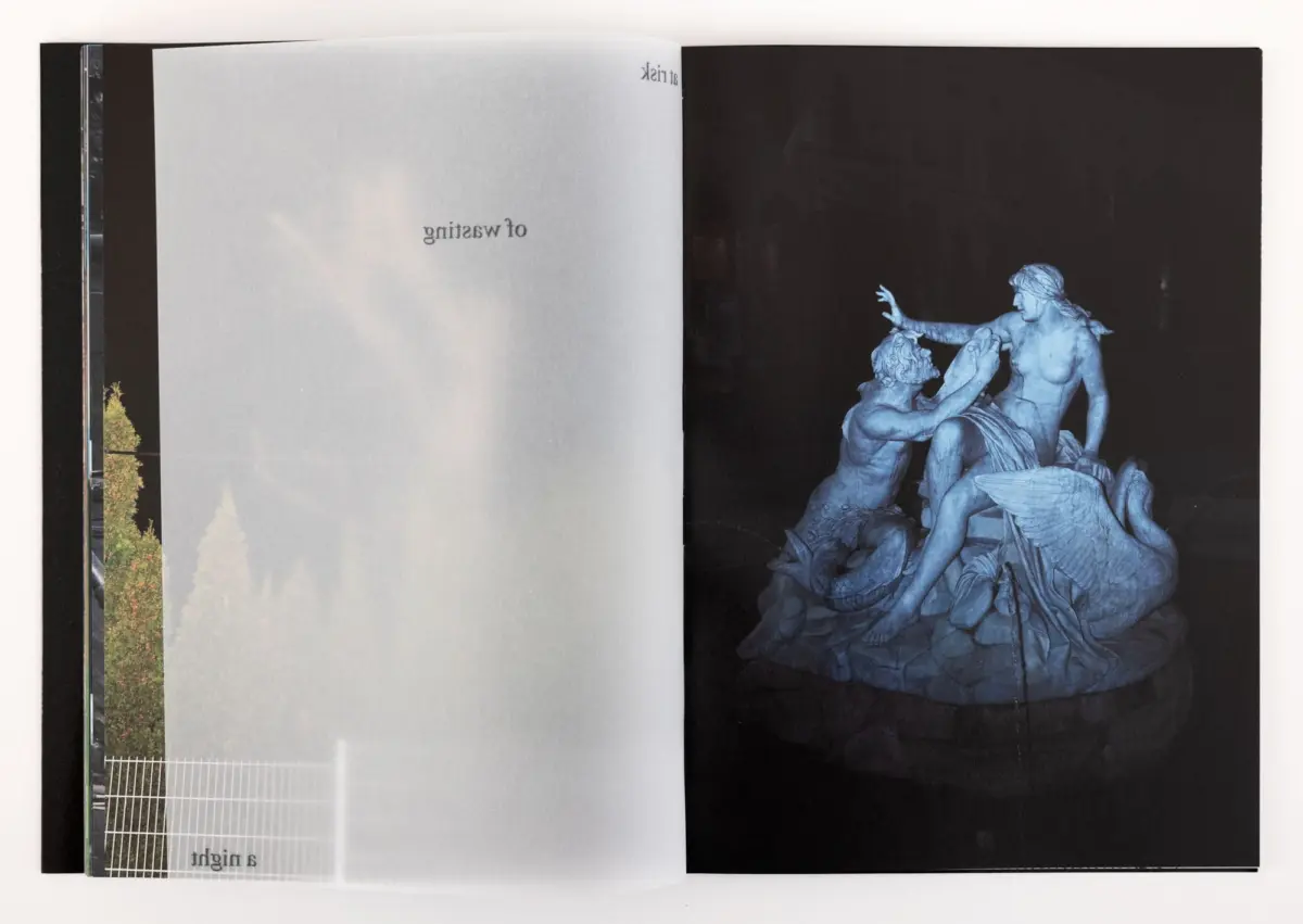 Blue-toned marble sculpture group of muscular men grappling across a dark background on the right page; left page is pale with upside-down text.