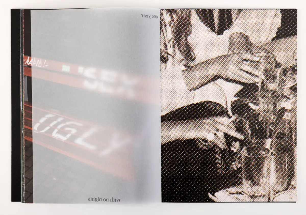 Open two-page book; left page plain gray, right page features a high-contrast halftone illustration on a white surface.