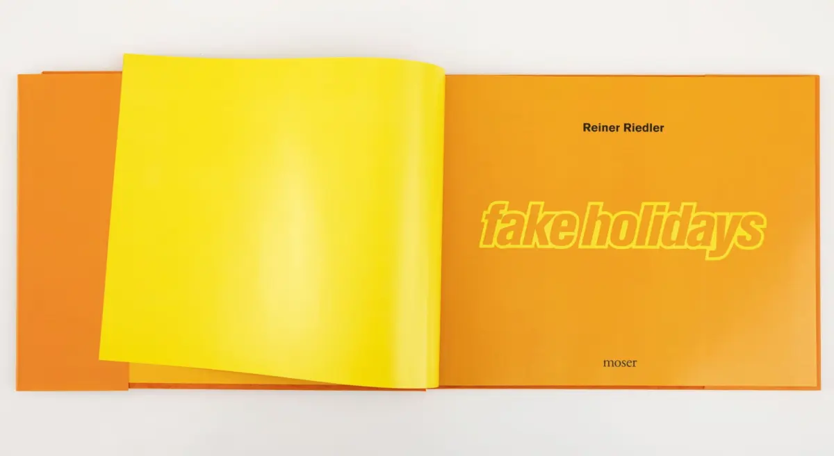 Open book spread with neon yellow left page and orange right page, displaying the title 'fake holidays' by Reiner Riedler.