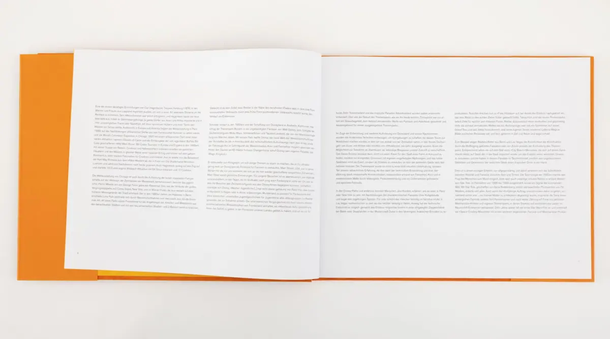 Opened orange-covered book with white pages on a white background.