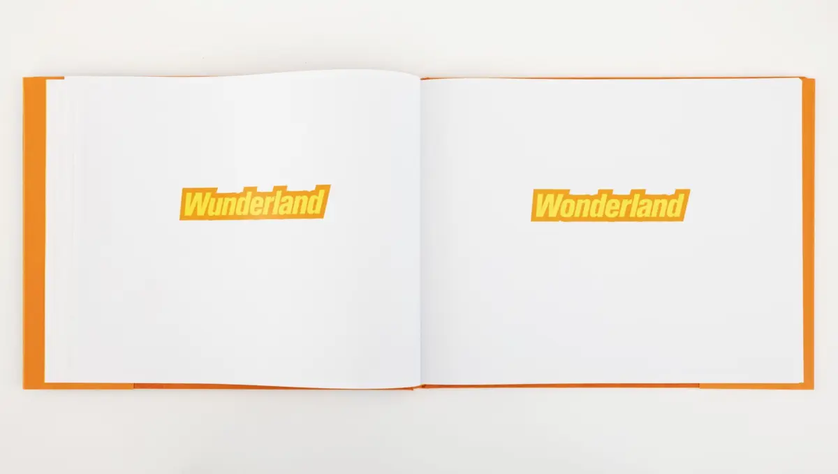 Open book with two white pages and orange binding, each page displaying the bold orange word Wunderland.