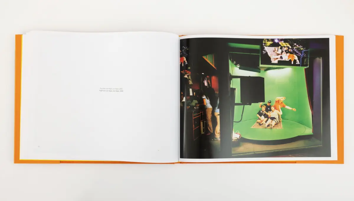 Open photo book on a white surface with an orange spine; right page shows a green-screen studio with people posing.