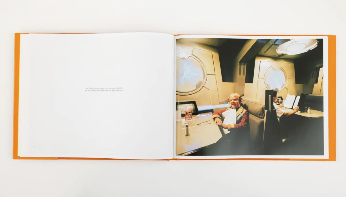 Two individuals sit at futuristic control consoles in a Star Trek-style spacecraft interior with round porthole windows.