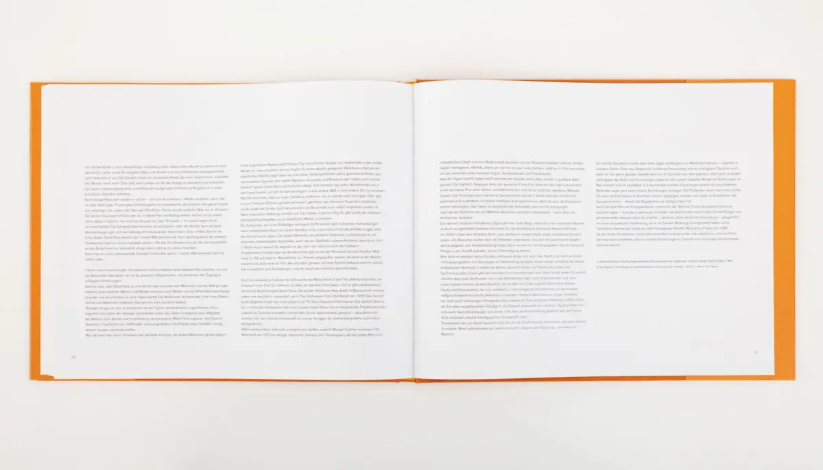 Open hardcover book with orange cover, pages spread on a white surface, viewed from above.