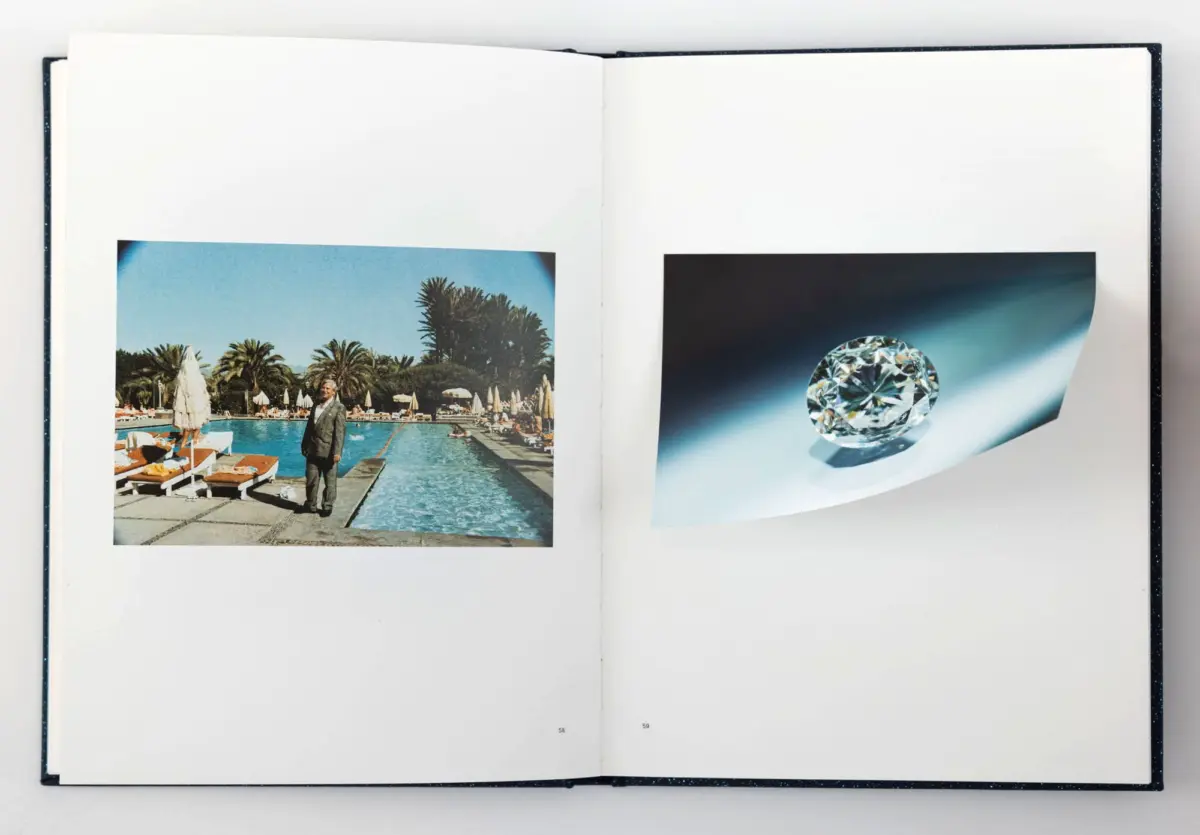 Open book spread: person in suit standing by pool at a palm-tree resort; right page shows a large diamond graphic on a blue gradient.