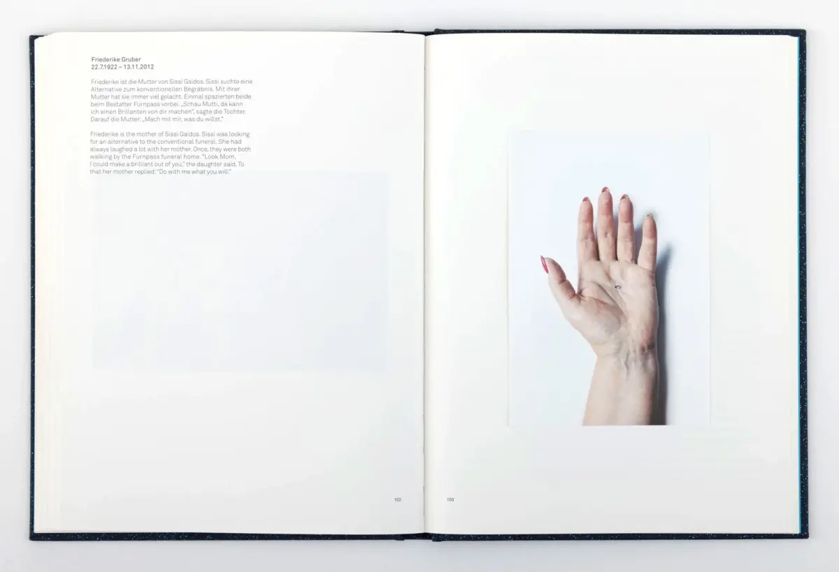Open book spread; left page has German–English bio of Friederike Gruber; right page shows a hand with red nails over white.