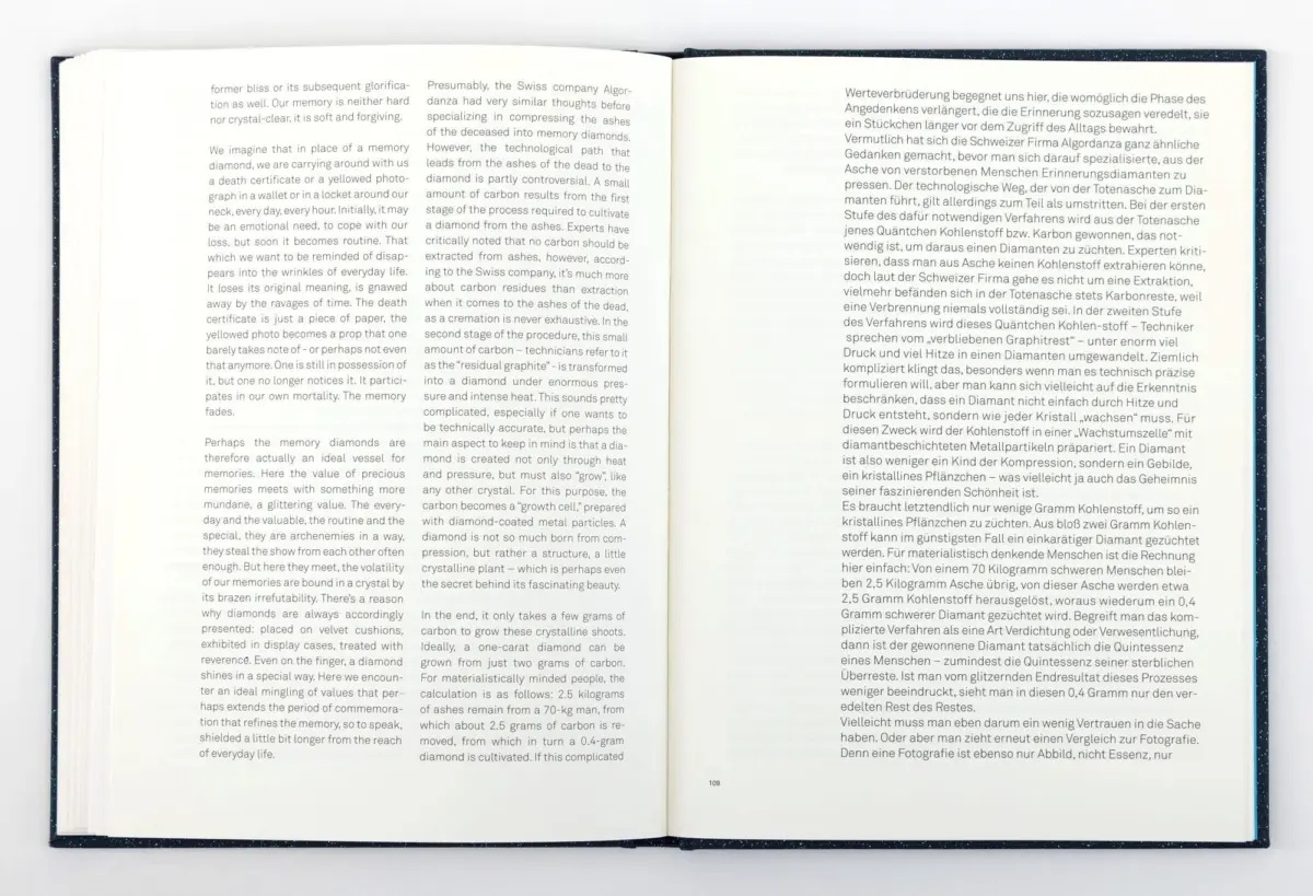 Open hardcover book spread flat on a white surface, showing two pages of dense text in multiple columns.