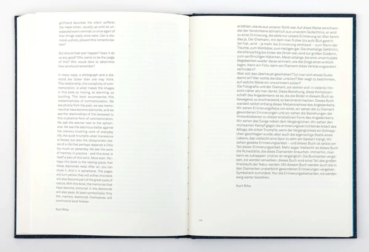 Open book spread with English text on left page and German text on right page, lying on a white surface.