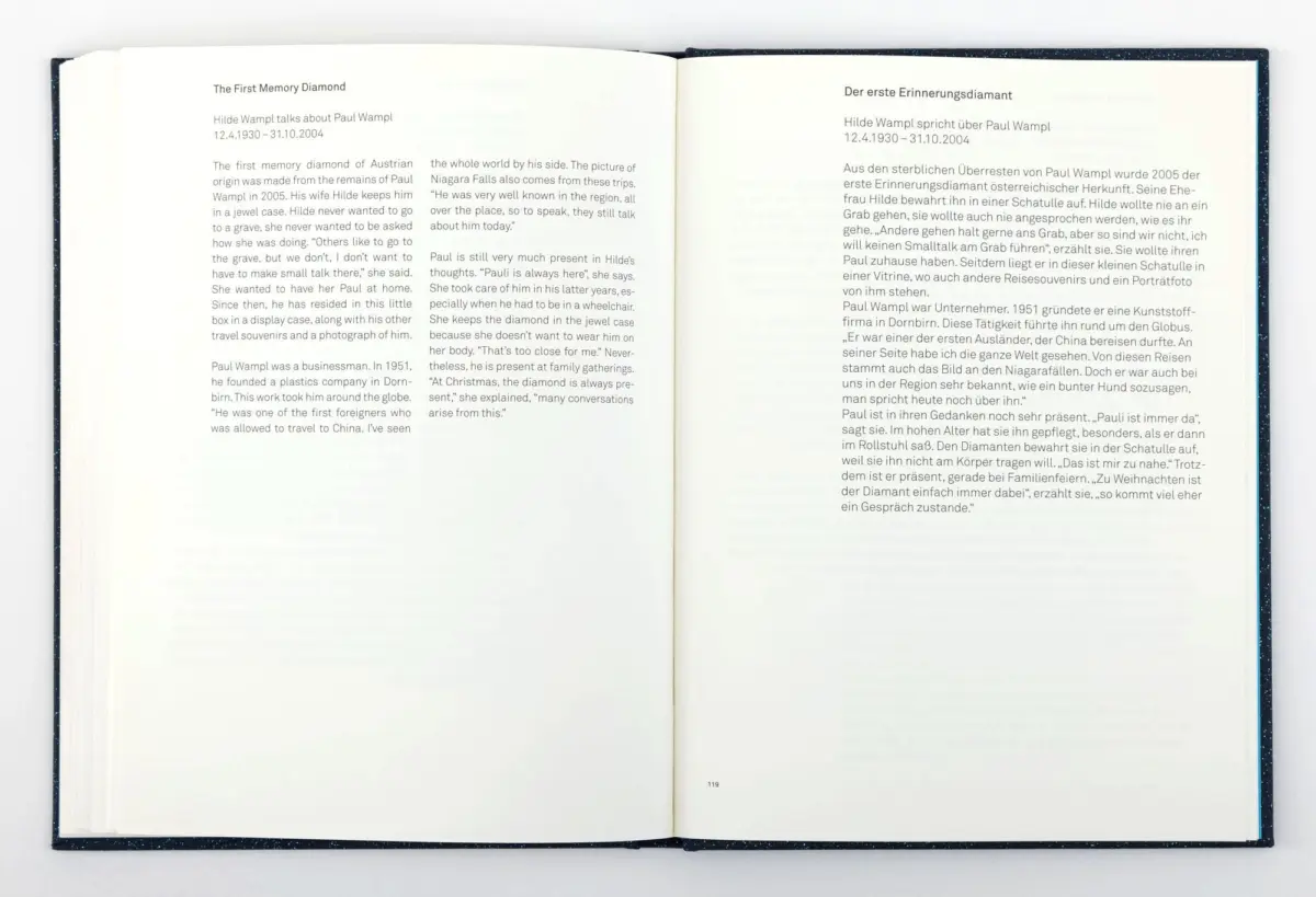 Open book with a two-page spread of English and German text on a white surface.