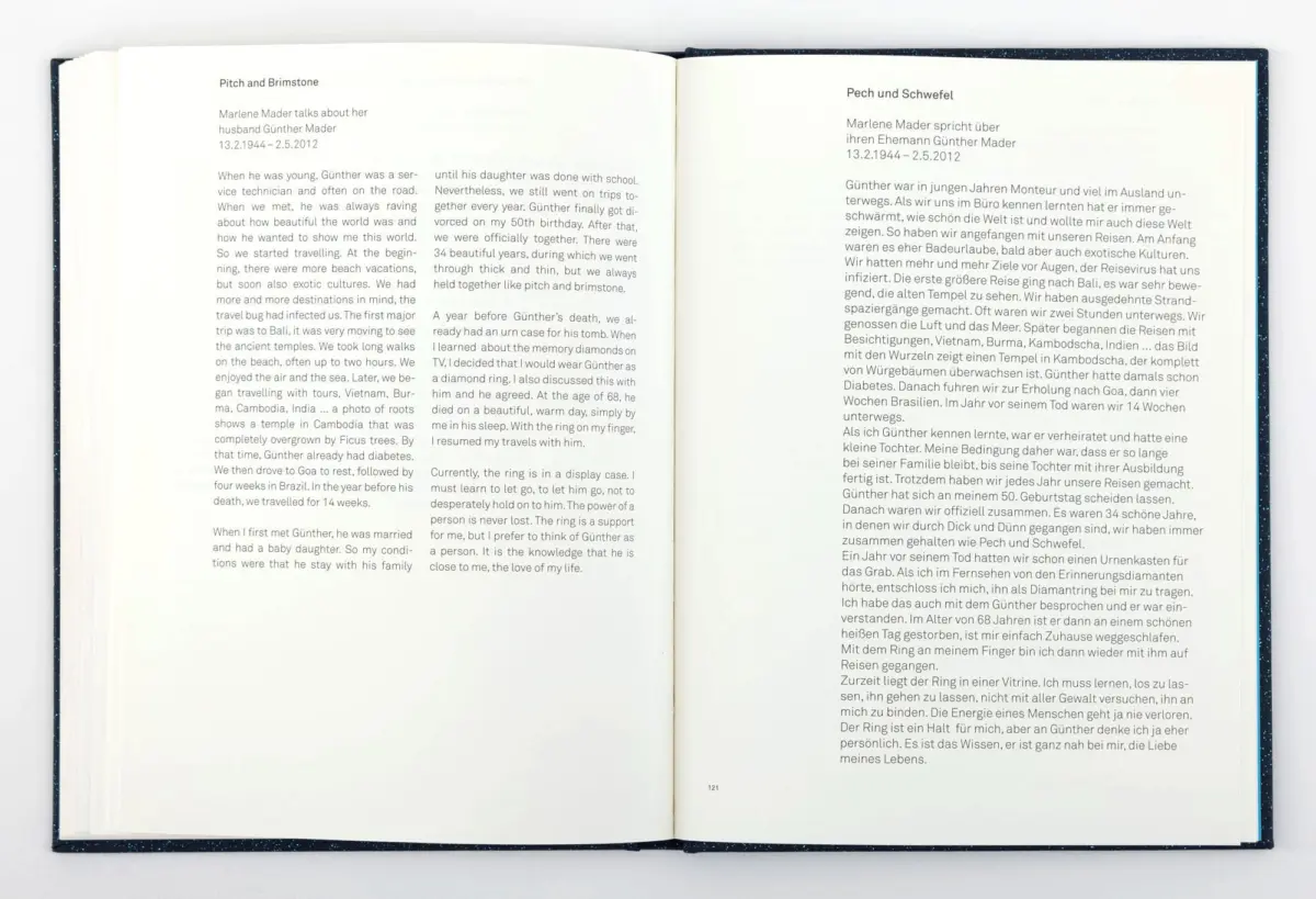 Open hardcover book laid flat on a white surface; two-page spread with English text on the left and German text on the right.