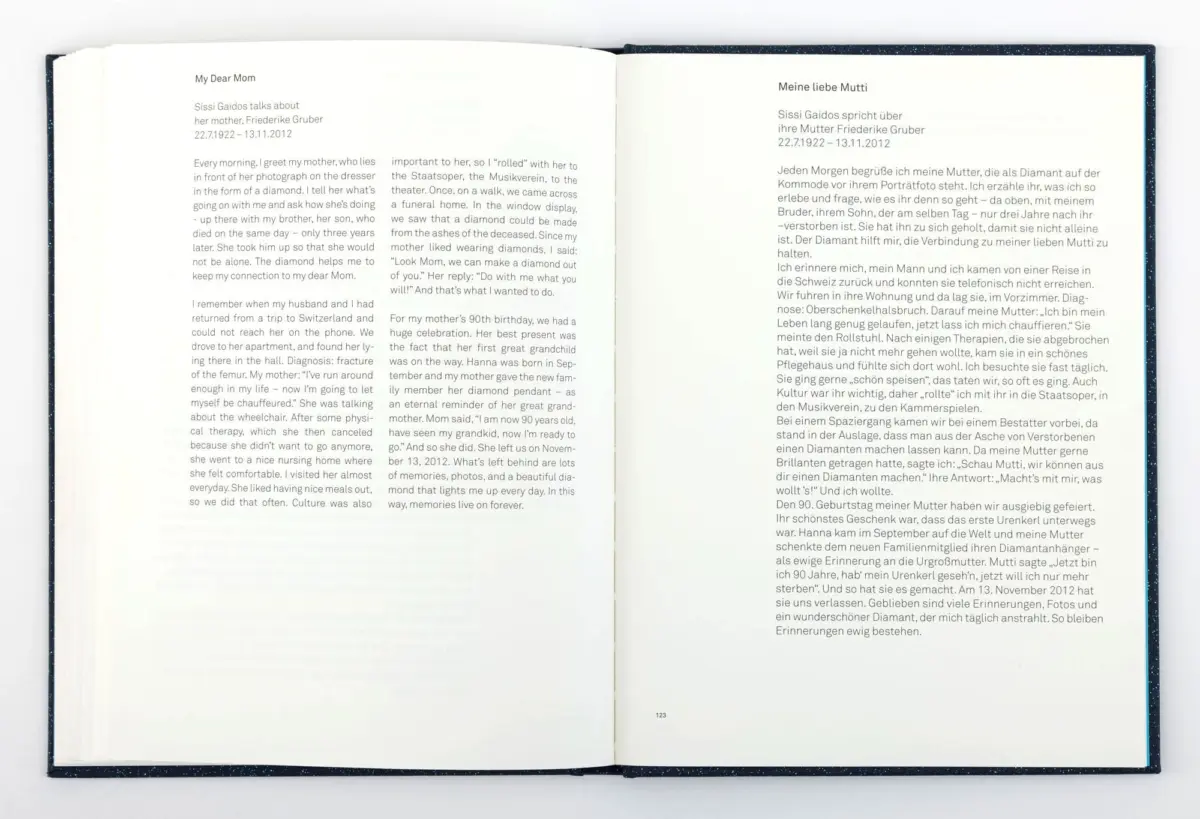 Open hardcover book with two facing pages of dense text; left page titled My Dear Mom (English), right page Meine liebe Mutti (German).