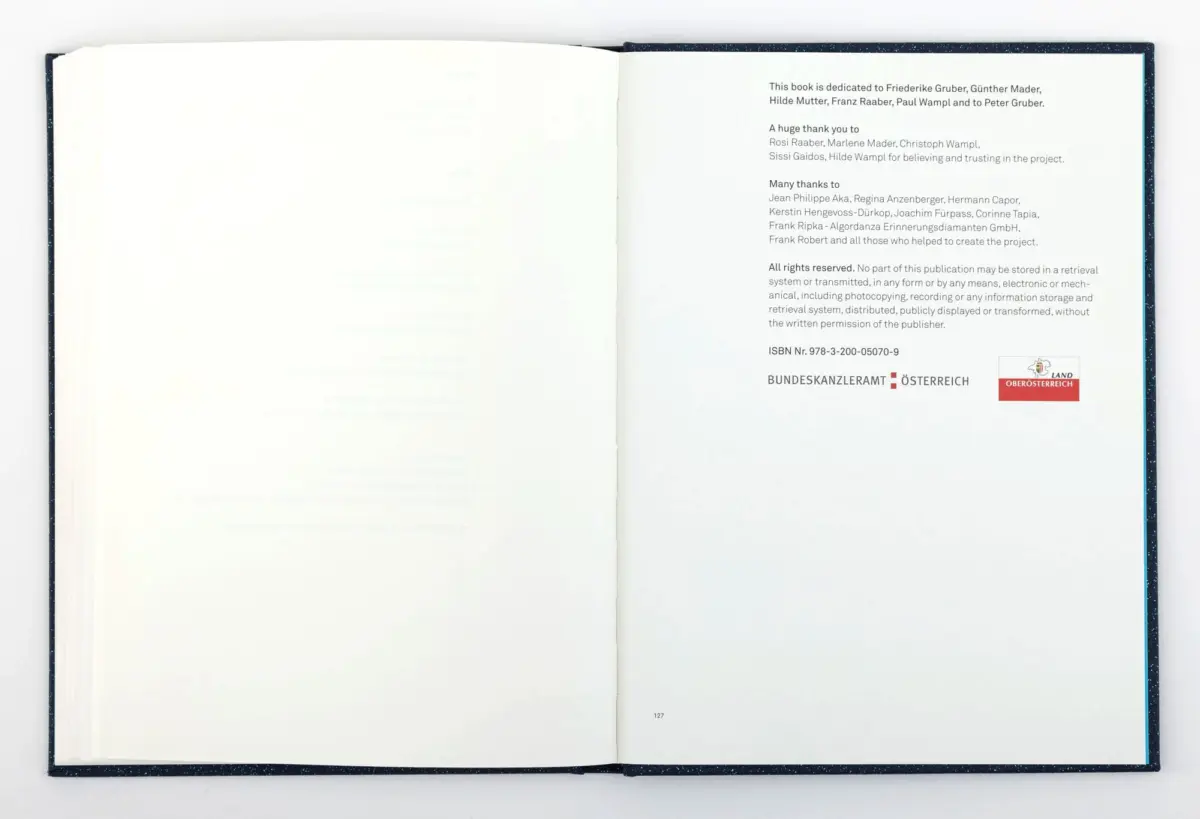 Open book photographed flat, showing right-hand dedication page with acknowledgments text and Austrian government logos.