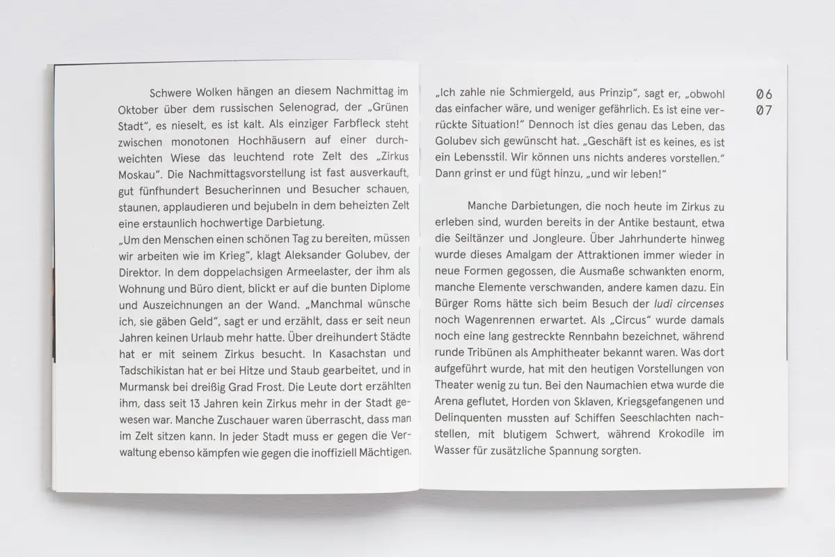 Open two-page German book on a white surface, dense text on both pages.