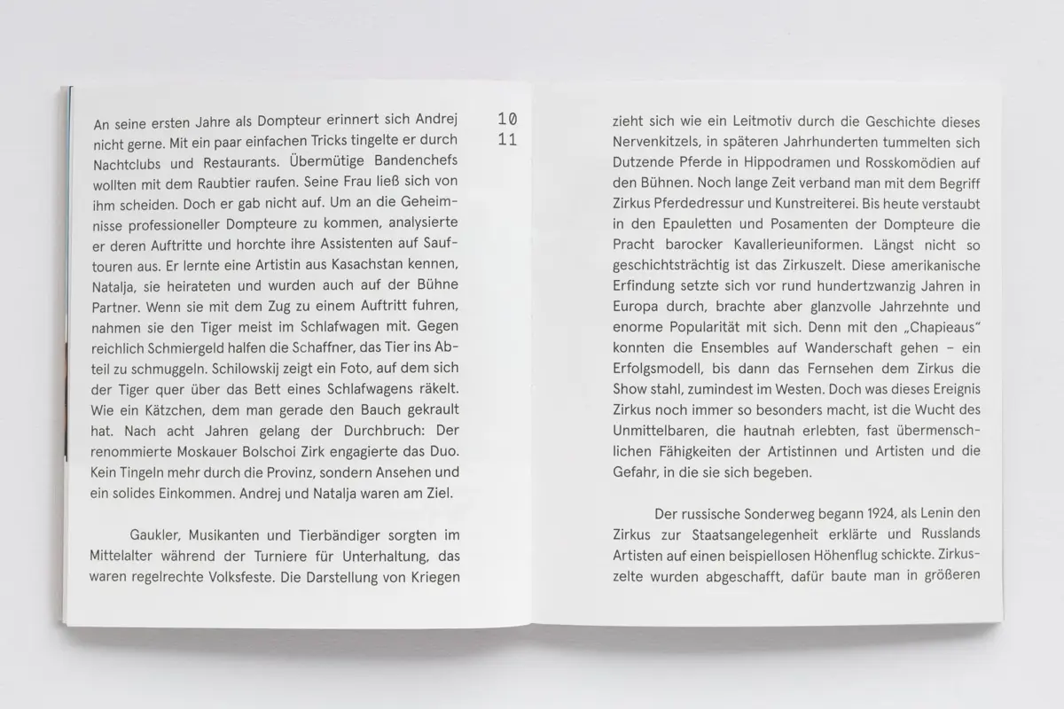 Open book with two facing pages of German text on a white surface; visible page numbers 10 and 11, blue spine on left.
