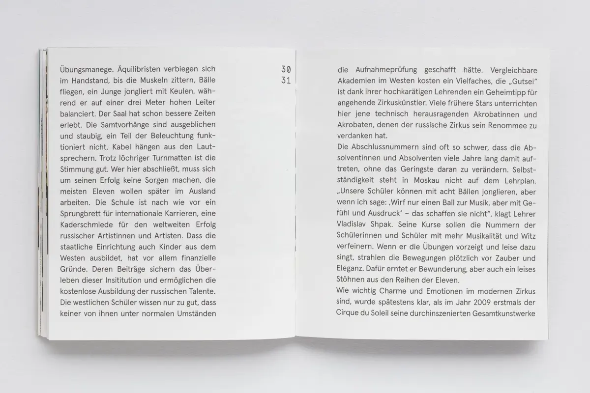 Open book with a two-page spread of dense German text, resting on a light gray surface.
