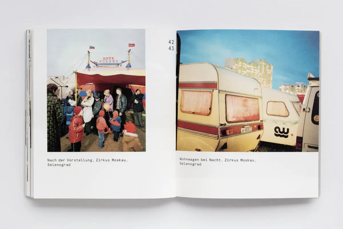 Open book with two photos: left shows daytime crowd at an outdoor circus tent; right shows a night scene with a caravan beside apartment buildings.