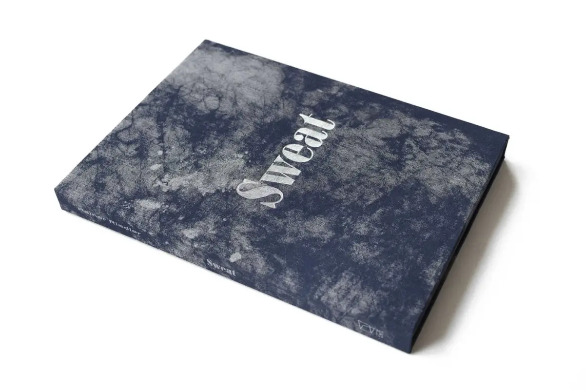 Marble-pattern navy notebook cover with white text, angled on a white background.