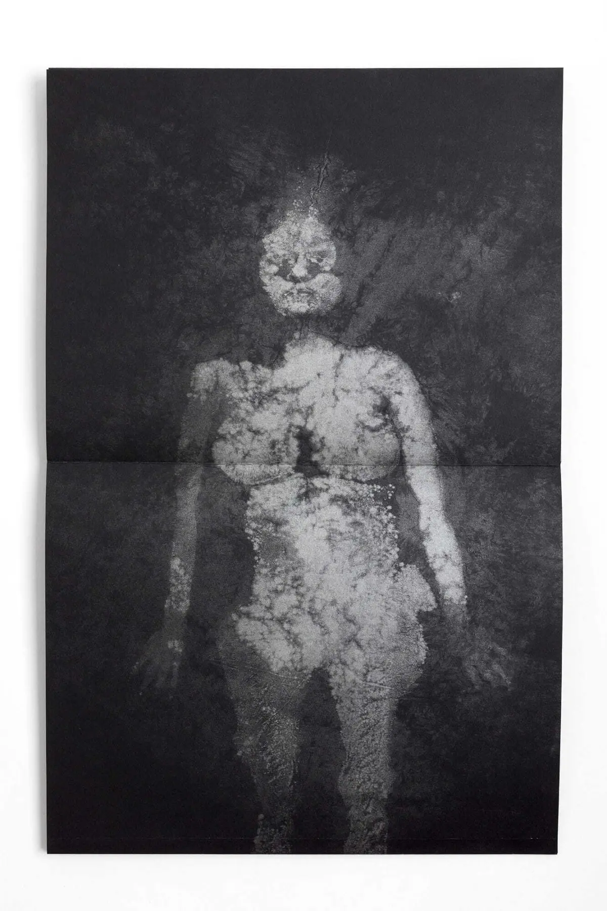 Cracked-white humanoid silhouette standing against a dark, textured background.