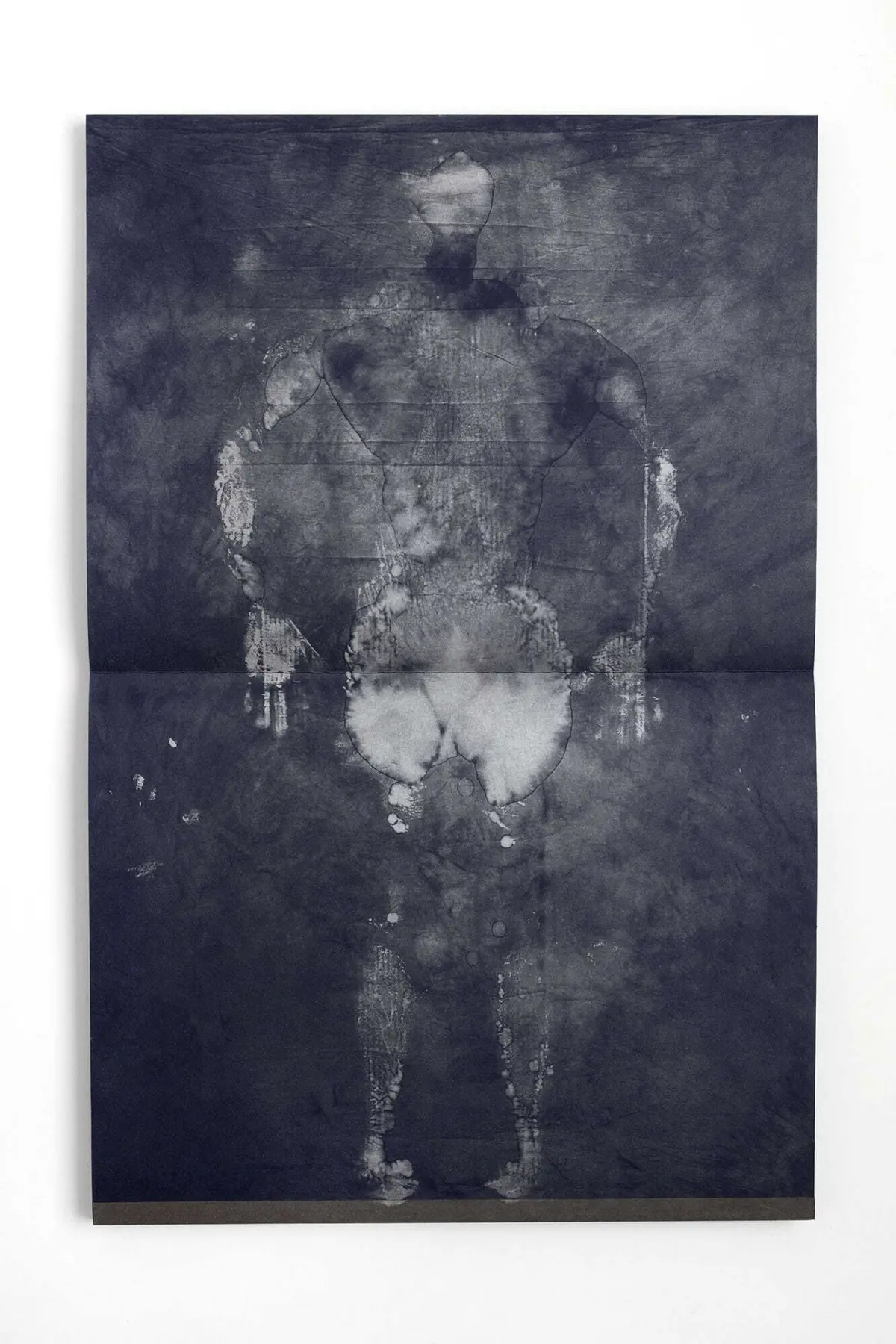 Standing human silhouette on a dark, textured blue-gray surface with cracks.