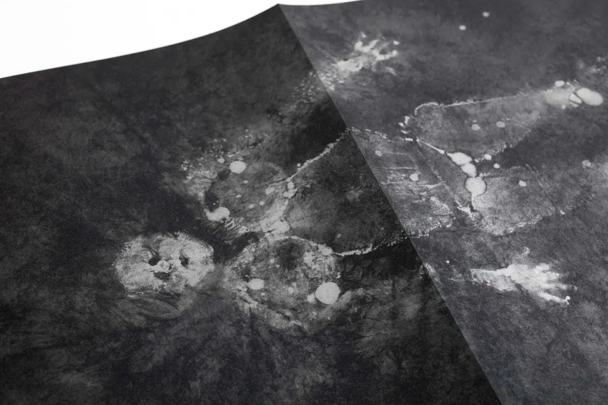 Abstract grayscale image showing two diagonal, overlapping dark planes over a marbled texture.