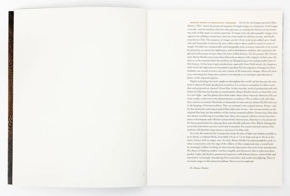 Open book with blank left page and densely printed right page; brown textured spine visible along the left edge.