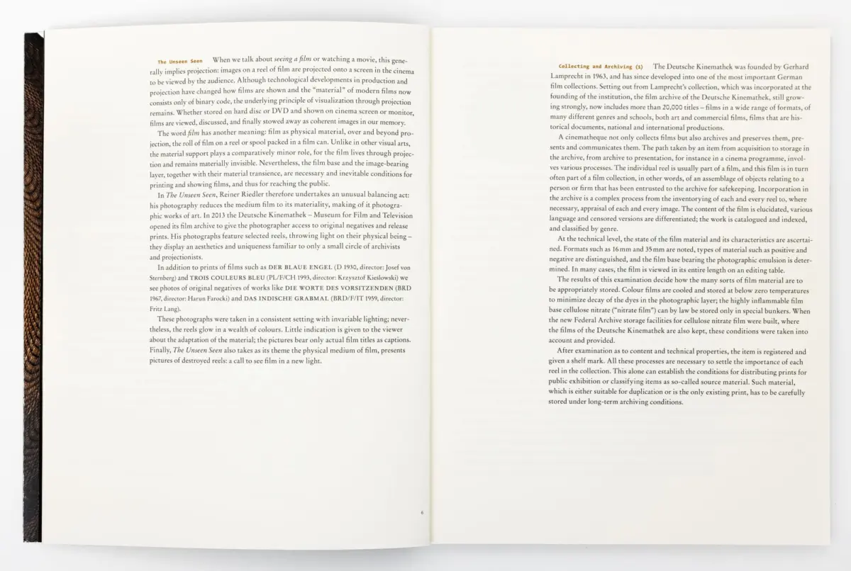 Open book on a white surface, two-page spread of dense text; left page titled "The Unseen Seen", brown cloth spine visible along the left edge.