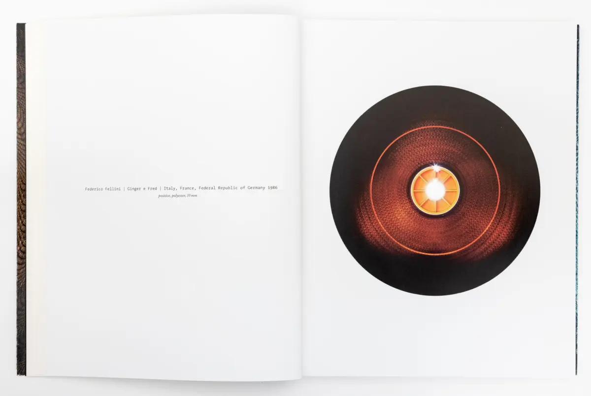 Open book spread with a large red vinyl record on the right page; left page mostly blank.