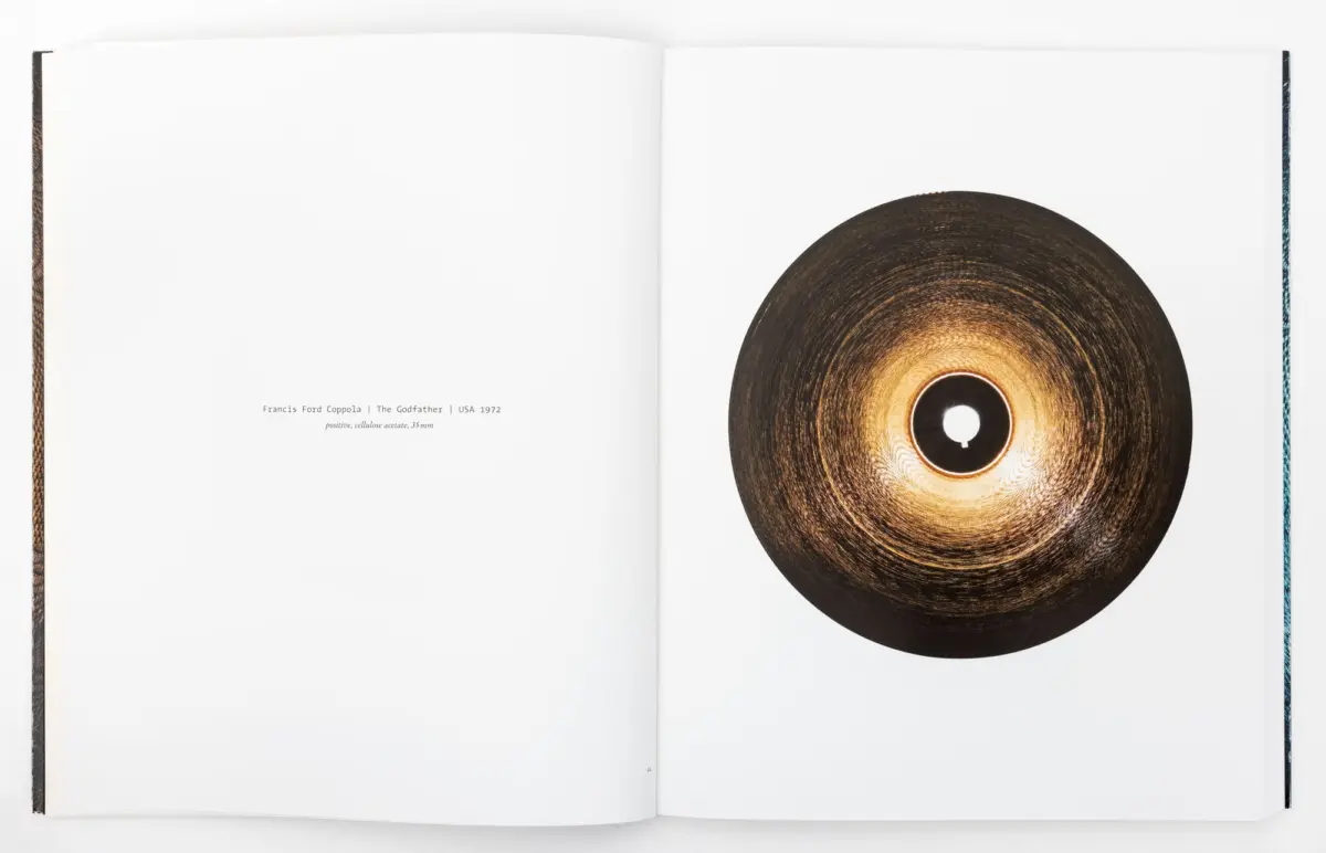 Open book with a large brown vinyl record on the right page; left page blank.