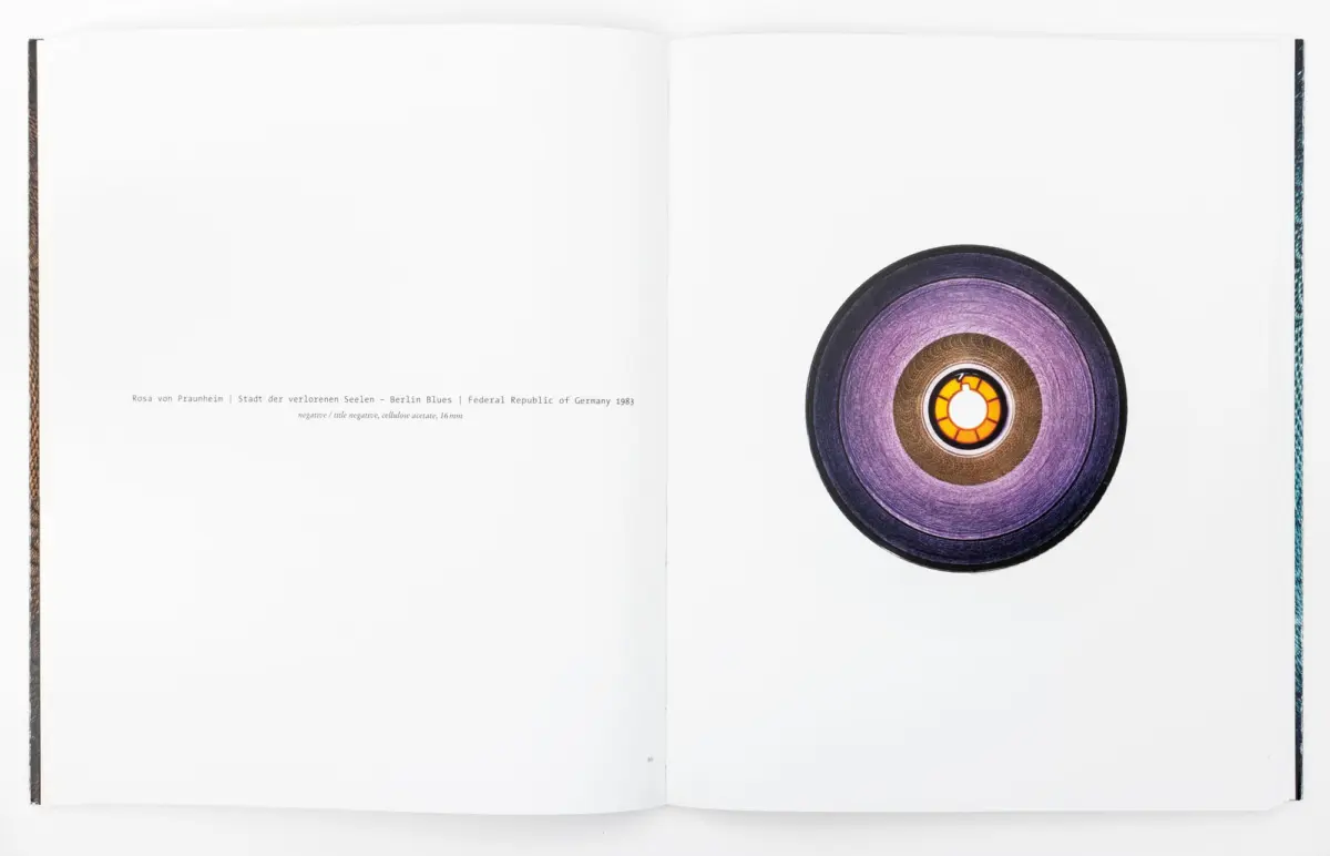 Open book spread with a purple vinyl record on the right page against white pages.