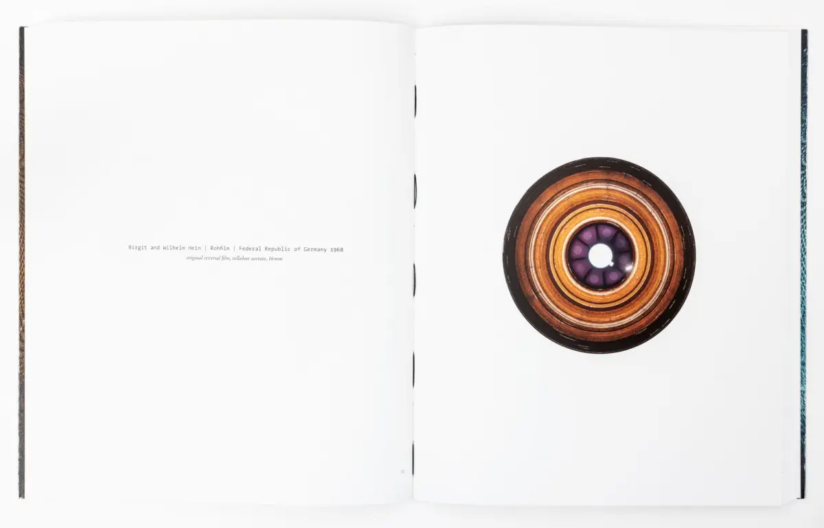 Open book spread with a large circular concentric-ring disc on the right page; left page is blank.