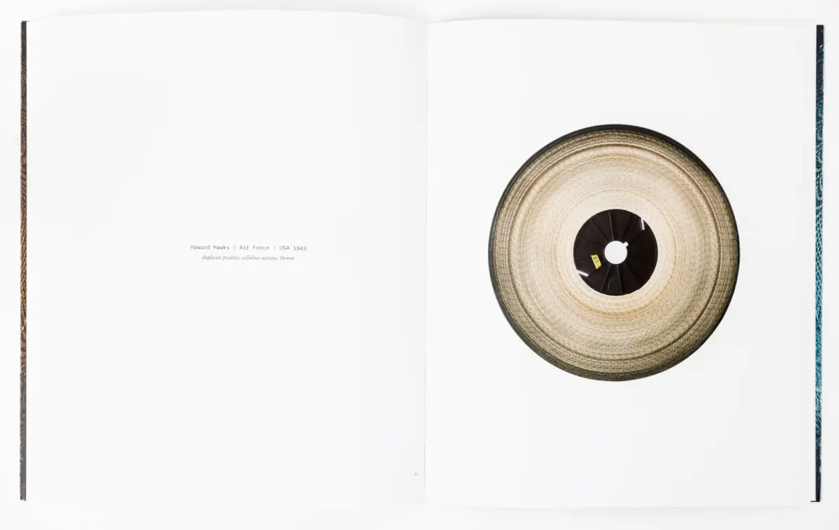 Open book spread with a large film reel on the right page; left page contains a caption about Howard Hawks' Air Force (1943).