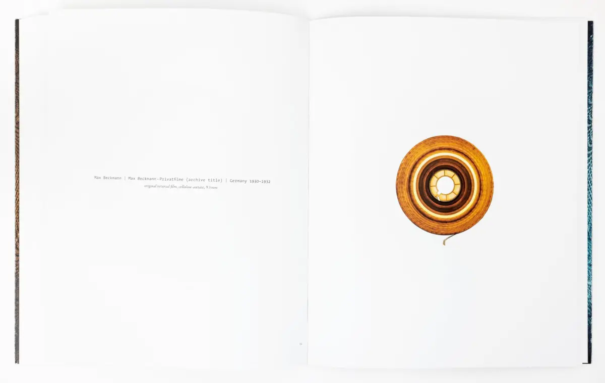 Open book showing a circular wooden reel on the right page against a white spread.