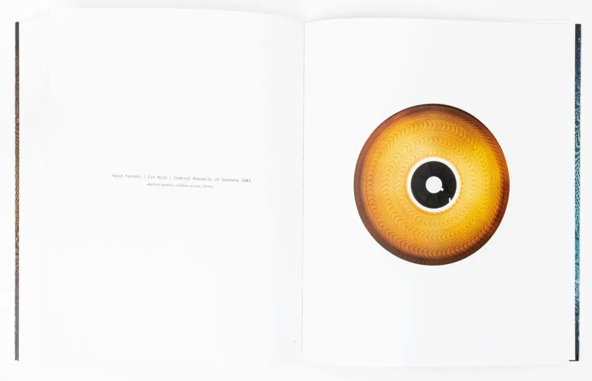 Open book spread with a large orange circular object featuring a spiral pattern on the right page.