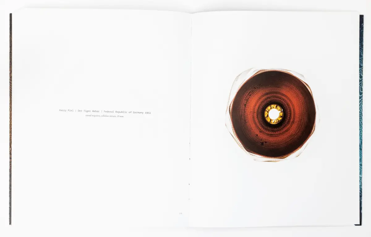 Open book spread with white pages; a brown circular disc sits on the right page.