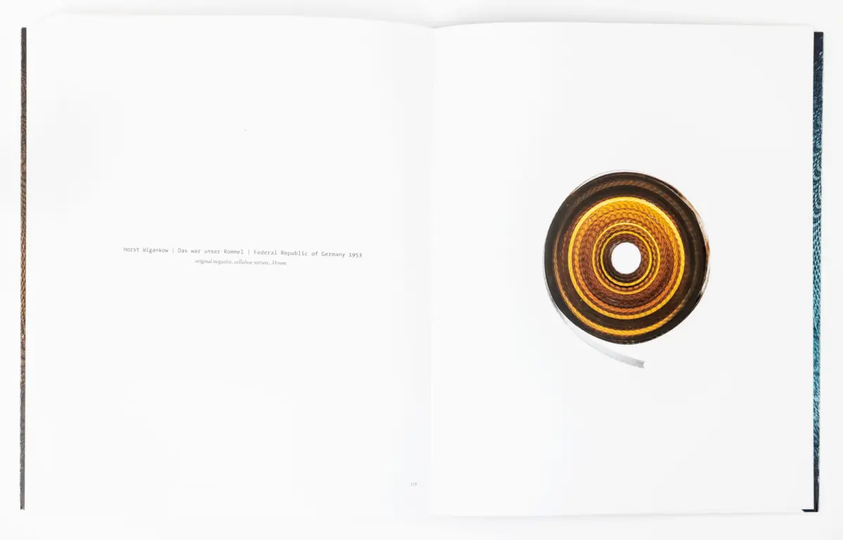 Open book with white pages; a striped circular disc with concentric rings rests on the bottom-right of the right page.
