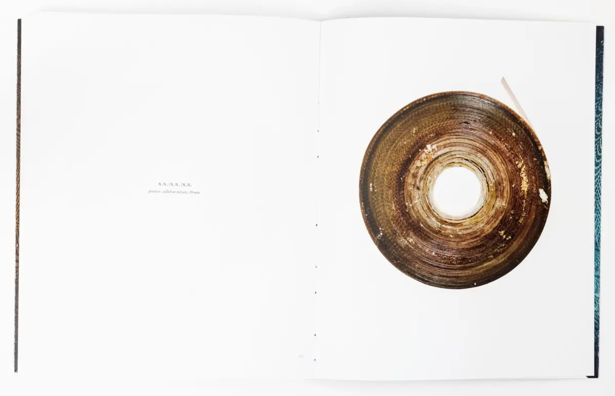 Open book with blank pages; on the right page a large brown circular ceramic plate with concentric rings.