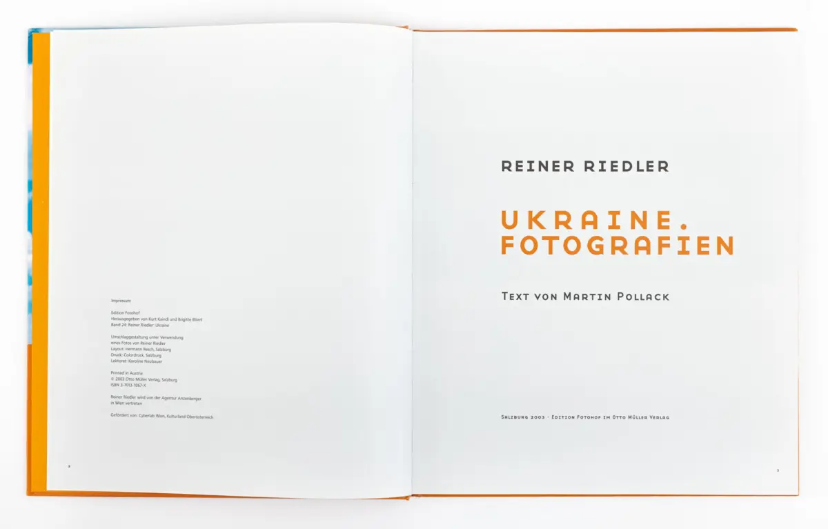 Open book spread displaying title pages: 'REINER RIEDLER' and orange 'UKRAINE. FOTOGRAFIEN' on the right; left page mostly blank.